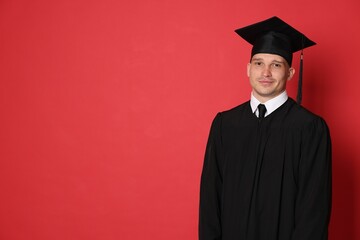 Student after graduation on red background. Space for text