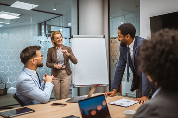 Mature businesswoman present new project to her colleagues in office