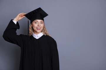 Happy student after graduation on grey background. Space for text