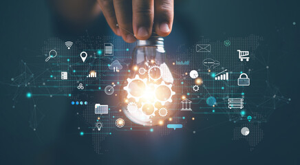 Futuristic innovative technology for global business concept. Businessman holding lightbulb with gears icon inside. Creative ideas innovation and inspiration for business. Internet network connection.