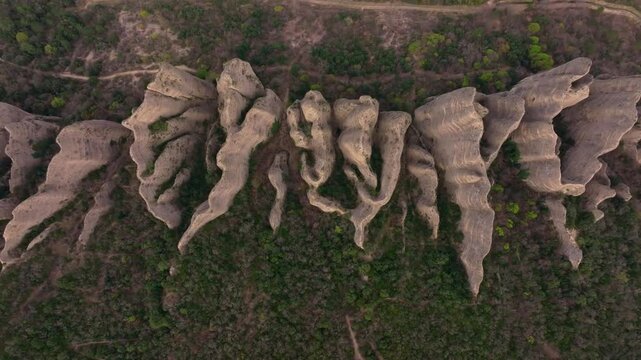 Aerial view of Les Penitents cliffs rising above Les Mees village, France. Aerial drone video