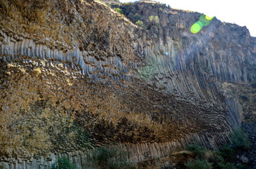 Hexagonal basalt column formations displayed on weathered cliff, showcasing unique geological patterns and structures resulting from volcanic activity and natural erosion. Symphony of stones, Armenia
