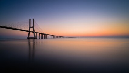 Fototapeta premium Vasco da Gama Bridge at Sunrise with Calm Water Reflections in Lisbon Portugal Europe
