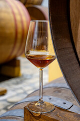 Visit of wine cellar with old large oak barrels, glass of fortified dry or sweet tasty marsala wine from barrels in Marsala, Sicily, Italy