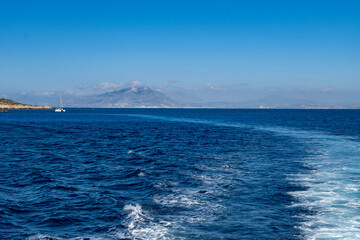 Boat trip and view on coastline of Favignana island with small village, shallow bays with clear turquoise water, tuff rocks, abandoned quarries, caves, Egadi Islands near Sicily, Italy