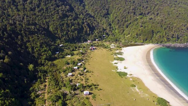 Cinematic aerial fly-in over Caleta Condor beach and forest, southern Chile