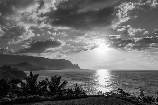 Scenic view of North Shore of Hawaiian island of Kauai with its famous Napali coast at sunset against blue sky with clouds in black and white