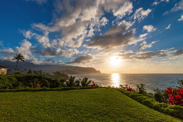 Obraz premium Scenic view of North Shore of Hawaiian island of Kauai with its famous Napali coast at sunset against blue sky with clouds