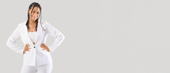 Stylish African-American woman with dreadlocks on light background