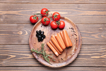 Plate with sausages, tomatoes and olives on wooden background