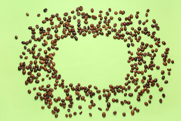 Frame made of coffee beans on green background