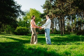 Obraz premium Couple enjoys a romantic moment while holding hands in a sunlit park