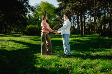 Obraz premium Couple enjoys a romantic moment in a sunlit park during springtime