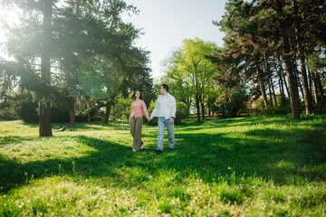 Couple enjoys a serene walk in a lush park during bright spring morning