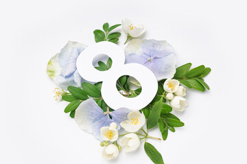 Green leaves and flowers with paper number eight on white background