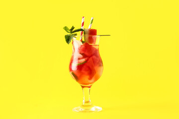 Glass of fresh watermelon lemonade with lime and mint on yellow background