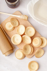 Wooden board with homemade tartlets on grey background
