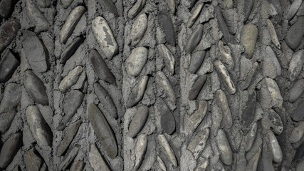 Fashionable dark background of a stone wall. Natural mountain stones in facade and interior design.
