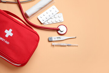 First aid kit and pills on beige background