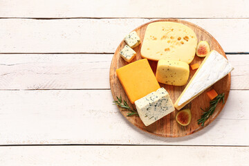 Plate with tasty cheese on white wooden background