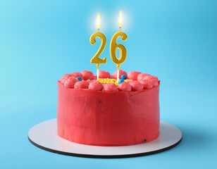 Yummy cake with burning number shaped candles on light blue background. 26th birthday or other special occasion