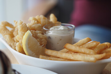 Delicious fried calamari and fries served with dipping sauce