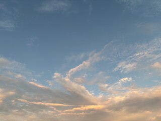 calm sky photo with soft and thin clouds golden light of the sun, light and shadow on the clouds create texture, bright blue sky calming background. Suitable for nature, tranquility, weather, freedom