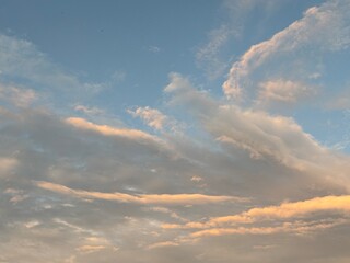 calm sky photo with soft and thin clouds golden light of the sun, light and shadow on the clouds create texture, bright blue sky calming background. Suitable for nature, tranquility, weather, freedom