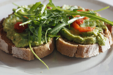 Delicious avocado toast with fresh greens and toppings