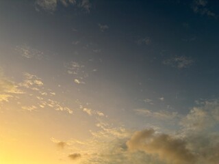 calm sky photo with soft and thin clouds golden light of the sun, light and shadow on the clouds create texture, bright blue sky calming background. Suitable for nature, tranquility, weather, freedom
