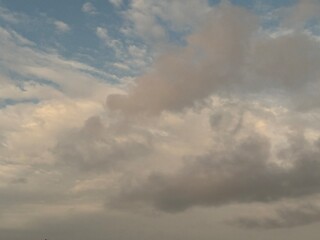 calm sky photo with soft and thin clouds golden light of the sun, light and shadow on the clouds create texture, bright blue sky calming background. Suitable for nature, tranquility, weather, freedom