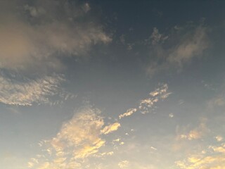 calm sky photo with soft and thin clouds golden light of the sun, light and shadow on the clouds create texture, bright blue sky calming background. Suitable for nature, tranquility, weather, freedom