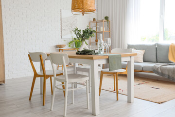 Interior of light room with dining table and sofa