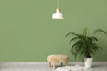 Stylish living room with comfortable pouf, rug, houseplant and white hanging lamp