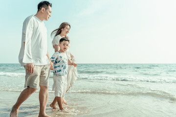 On vacation, travel, or a long weekend, spend time together with family and have fun and happiness by walking hand in hand on a beautiful beach with sunset light.