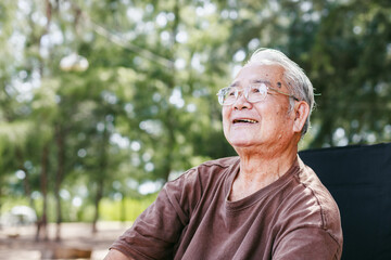 Happy elderly man enjoys summer day outdoors surrounded by trees, reflecting peaceful moments that bring joy and warmth to family camping activity in nature