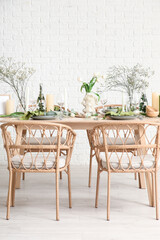 Elegant table setting with beautiful flowers and candles in light dining room