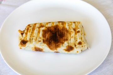 Close-up of a delicious shawarma wrap held in hand