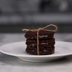 chocolate cookies arranged on a white plate with a marble table background