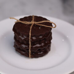 chocolate cookies arranged on a white plate with a marble table background