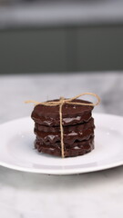 chocolate cookies arranged on a white plate with a marble table background