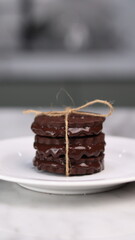 chocolate cookies arranged on a white plate with a marble table background