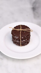 chocolate cookies arranged on a white plate with a marble table background