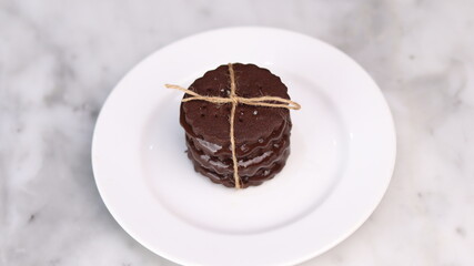 chocolate cookies arranged on a white plate with a marble table background