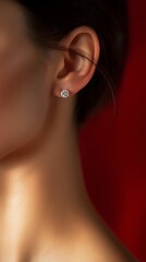 Close-up view of a diamond stud earring on a woman's ear.