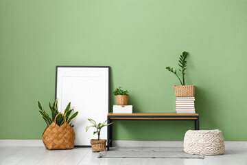 Interior of room with bench, frame and green plants in wicker baskets