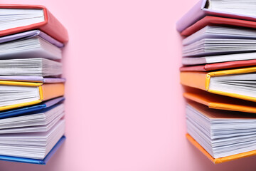 Open colorful books on pink background