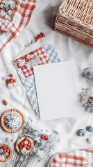 A cozy picnic setup with a red and white checkered blanket, dried flowers, blueberries, strawberries, and a wicker basket on a white background