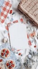 A cozy picnic setup with a blank paper on a red and blue checkered tablecloth surrounded by dried flowers, berries, and a wicker basket