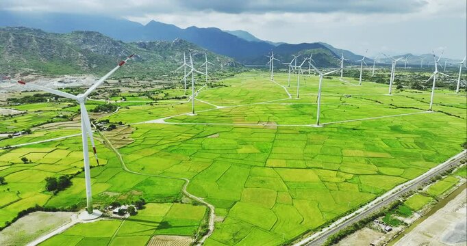 Panoramic view of wind farm or wind park. Wind turbines generating electricity on rice field at Phan Rang, Ninh Thuan, Vietnam. Clean energy concept